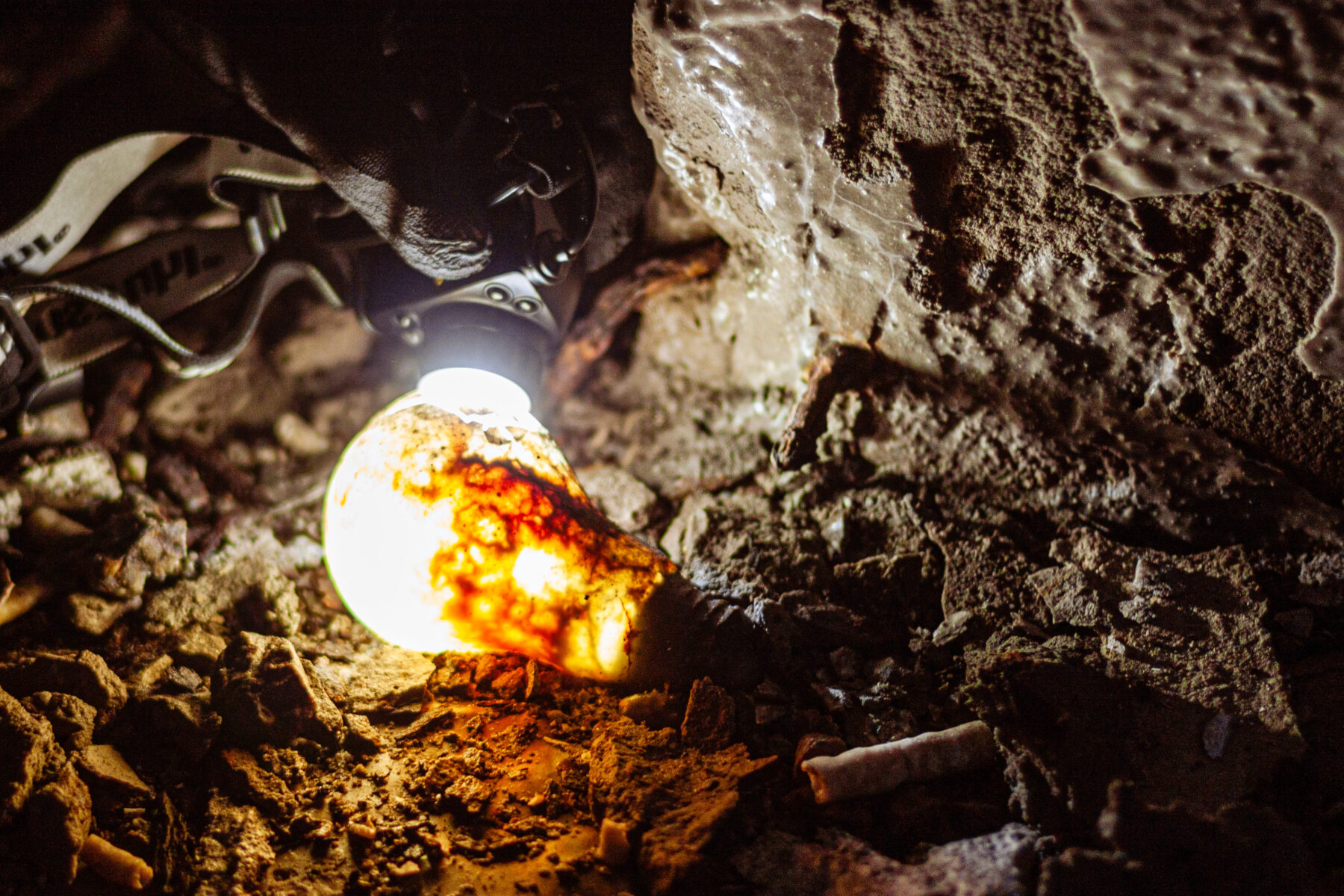 Old lightbulb in the bunker illuminated by a flashlight