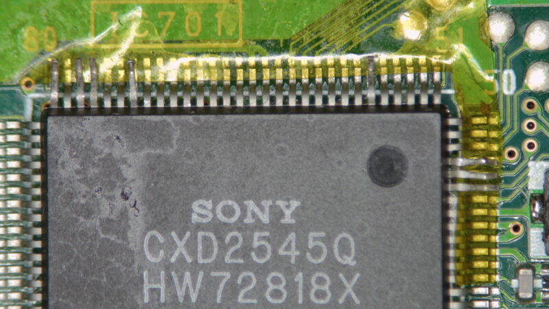 Angehobene Pins des CXD2545Q Controllers unter dem Mikroskop
